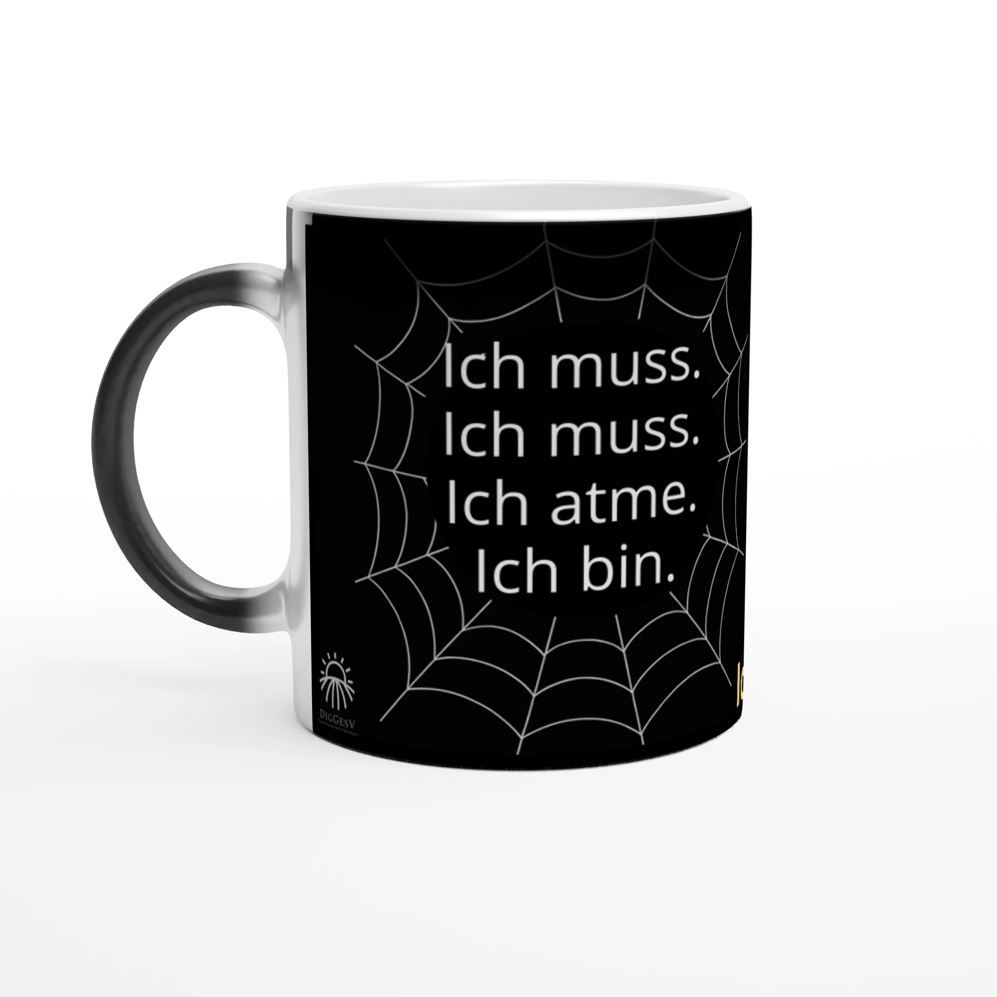 Schwarze Tasse mit einem Spinnennetz-Muster. Auf der Tasse steht: 'Ich muss. Ich muss. Ich atme. Ich bin.'